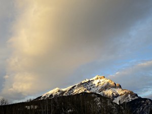 The snow-capped Cascade Mountain turning golden in the setting sun