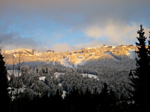 As the sun sinks lower it lights up the ski runs at the top of the mountain a golden colour