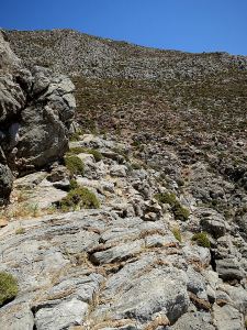 Along a narrowing ledge marked by small cairns (centre)