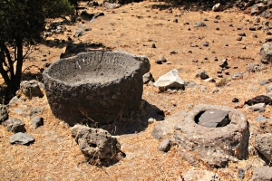 Large basin carved from lava and fragment of imported marble container alongside a sterna