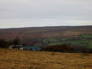 Looking across the sepia-coloured grass on the high acid moorland, the Foxhunter masts just visible, the path zigzagging off to the left and then back right to avoid the valley
