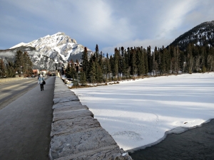 Looking across the town bridge built in 1923, Cascade Mountain at the end of Banff Avenue, the Bow River partly snow covered,partly flowing water