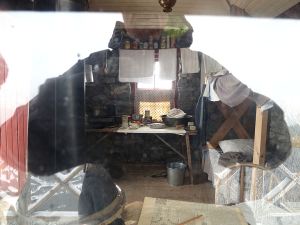 Reflected voyeur and the interior of  the hut, preserved for posterity