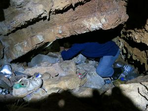 Crawling past the rubbish through a narrow overhang before dropping down vertically