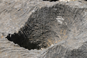 A large serrated-edged hole in the rock