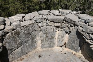 Detail of one of the restored presses showing the flat slab floor, the slab-and-drystone walls and the outlet for the must
