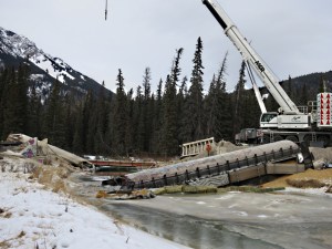 Bridge gone, derailed wagon left across the creek to dam it