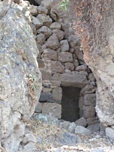 Shallow cave walled up to make a dwelling in the rocks.  Note the substantial lintel and door frame.
