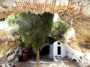The underground church with the remnant of the arched terracotta roof and the cave with the thermal spring in the background