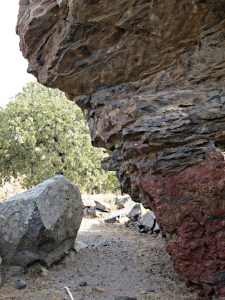 As far as this large overhanging lava boulder the way is fairly obvious, first a stone-paved kalderimi, then a narrow but well trodden path.  But from here on it’s a ‘route’, follow the dry stream bed or find your way along animal tracks
